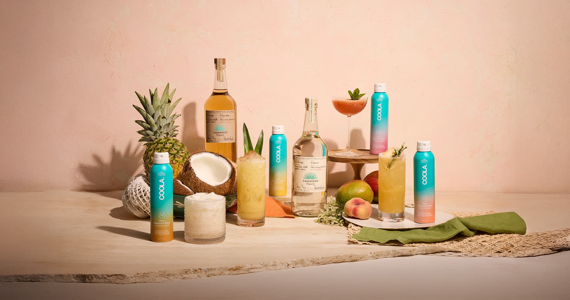 Summer cocktails surrounded by bottles of Casamigos tequila and Coola sunscreen